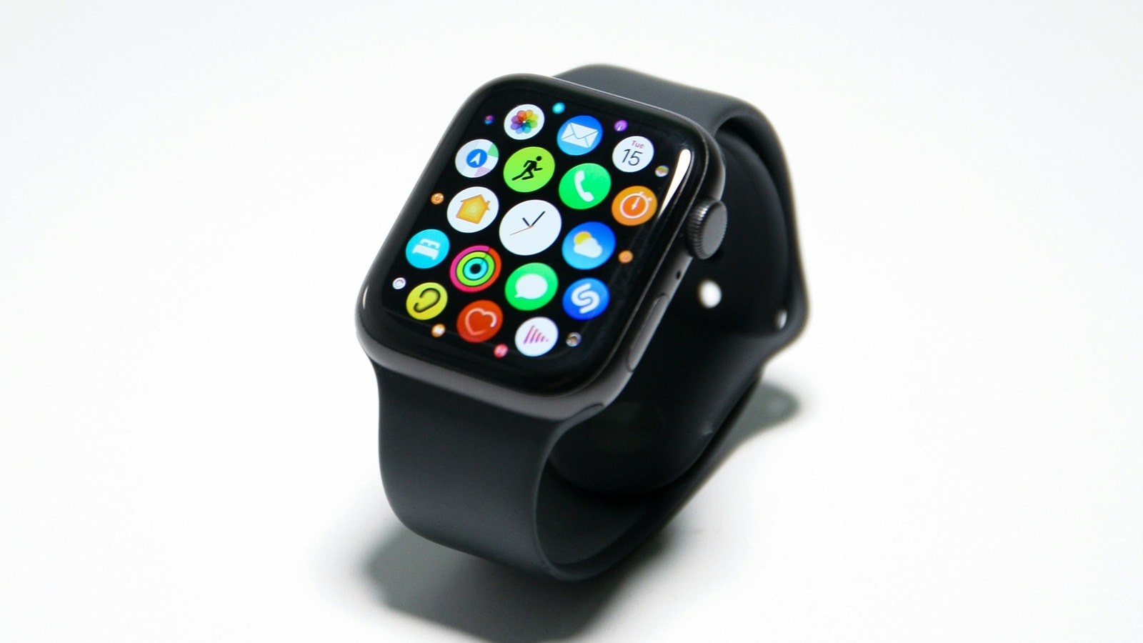 Apple Watch SE i svart med sportband och appvy på skärmen mot vit bakgrund.
