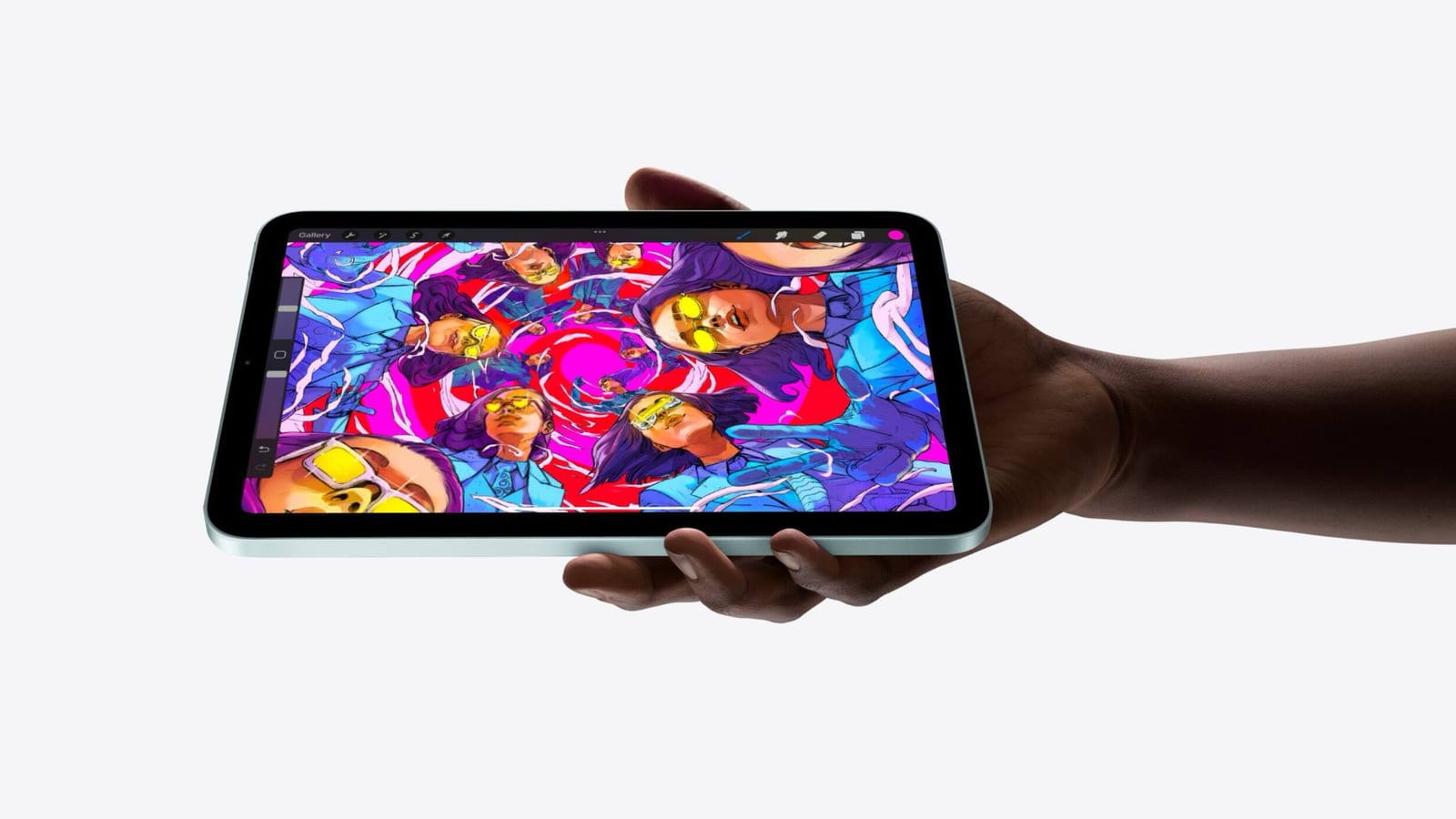 En hand håller upp en iPad mini i blågrönt med ett färgstarkt Procreate-konstverk på skärmen.