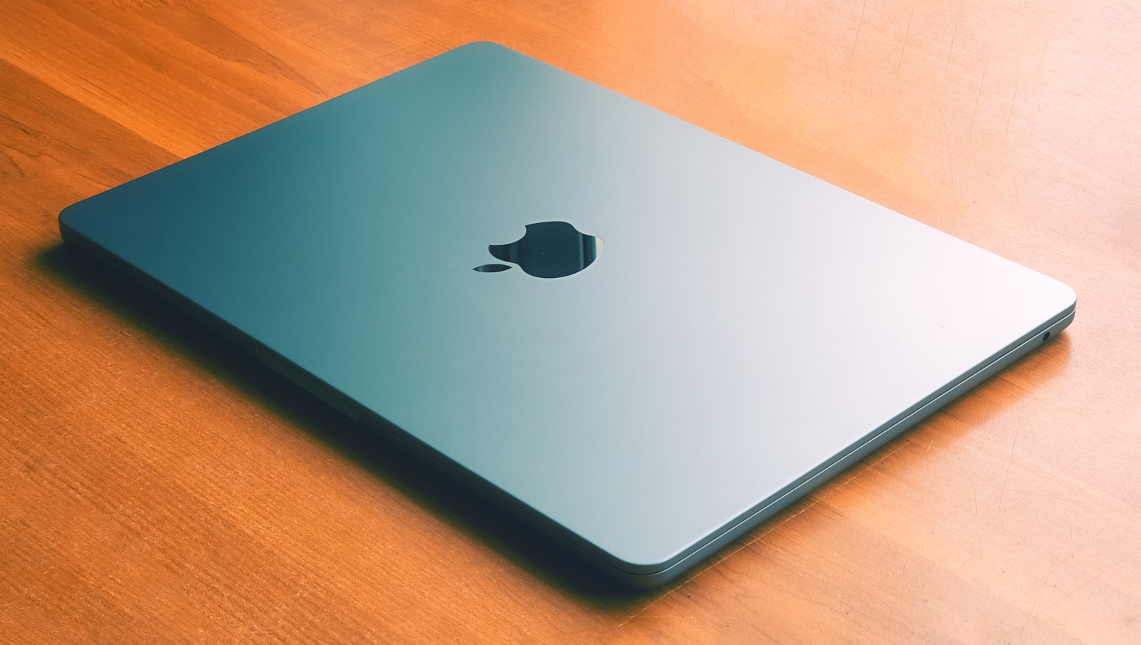 En stängd MacBook Air liggande på ett träbord